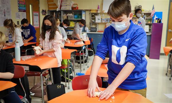 Boy flattens salt dough